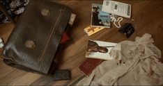 the contents of a purse are laid out on the floor next to books and other items