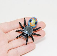 a small spider sitting on top of a person's hand