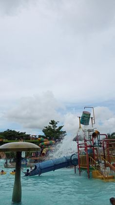 the water park is full of people and has a splash machine in the middle of it