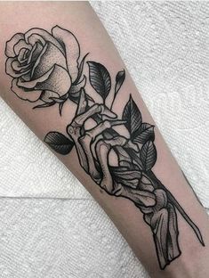 a black and white rose tattoo on the arm