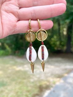 These cowrie shell beaded earrings are gorgeous. They look good with any outfit. They are one of kind and unique.  They are delicately designed with gold electroplated stainless steel components, cowrie shells, brass spiral beads, stainless steel spikes and accented with miyuki Picasso beads Ear post is a 14mm stainless steel huggie hoop Miyuki Picasso bead color burnt sienna  These earrings come to you in a white box ready for gift giving Please note colors may vary from picture, and it is advi Metal Beaded Earrings For Beach, Beach Beaded Metal Earrings, Metal Beaded Drop Earrings For Beach, Beaded Metal Drop Earrings For Beach, Wire Wrapped Beaded Drop Earrings For Festival, Festival Wire Wrapped Beaded Drop Earrings, Adjustable Bohemian Beaded Wrap Earrings, Handmade Spiral Earrings For Beach, Bohemian Spiral Wrap Earrings With Ear Wire