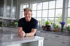 a man sitting at a kitchen counter with his hands on the table and looking off into the distance