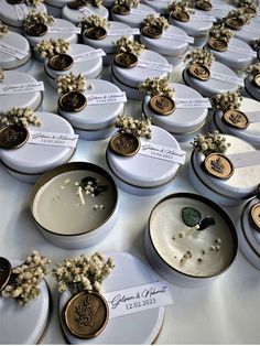 wedding favors are arranged on white plates with gold trimmings and flowers in them