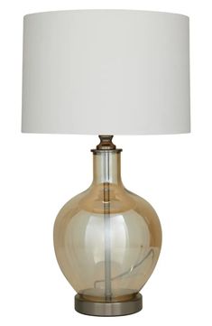 a glass lamp with a white shade on it