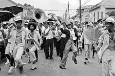 black and white photograph of people marching down the street with umbrellas in their hands