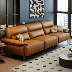 a brown leather couch sitting in a living room next to a window