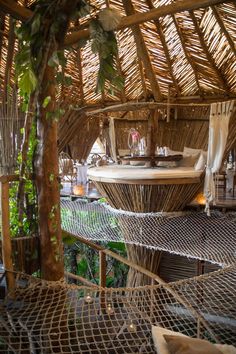 the inside of a hut with hammocks and tables on it's roof