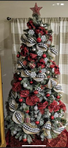 a christmas tree decorated with red, white and black ribbon