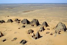 an aerial view of several pyramids in the desert