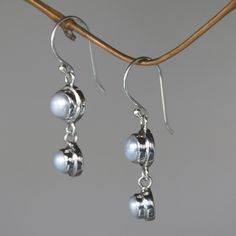 Silver moonlight radiates from luminous pearls, set in argent circles, they become dancing dangle earrings by Bali's Nyoman Rena. Pearls represent June´s birthstones. Sterling silver and freshwater cultured pearls Hook earrings Handmade in & fairly traded from Indonesia Adjustable Silver Pearl Drop Earrings, Silver Moonstone Jewelry With Pearl Drop, Silver Pearl Charm Earrings, Silver Dangle Pearl Earrings For Anniversary, Adjustable Silver Pearl Earrings For Anniversary, Silver Earrings With Pearl Charm, Adjustable Round Pearl Earrings For Anniversary, Silver Pearl Drop Earrings, Paw Print Jewelry