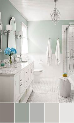 a bathroom with white and gray colors in the bathtub, toilet, sink, shower curtain, chandelier