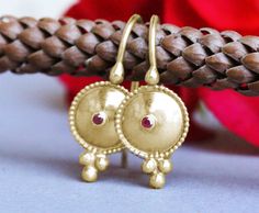 "Exquisite, antique-style very small ruby and 14k, 18k or 22k solid gold hook drop earrings. These amazing drop earrings have a decorated domed disc and a tiny red ruby set in the middle of it. At the bottom of the disc on each earring, there are three gold dots that add character to these boho earrings. These earrings are elaborate and delicate but still very noticeable. They have a unique eye-catching boho look that will go with and upgrade any outfit. Ruby is the birthstone of July and is con Gold Earrings Bridal, Boho Wedding Ring, 22k Gold Earrings, Dainty Gold Earrings, Jewelry Designing, Gold Bridal Earrings, 22 Carat Gold, 18k Gold Earrings, Earring Ideas