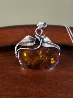 Unique One-of-a-kind Amber Piece Approximately 30x22mm natural Amber cabachon, a beautiful chunky slab of Amber set in an east/west orientation. It is bezel-set into a handcrafted Sterling Silver setting that features leaves across the top that kind of wrap around the edges. Generous bale will fit most any chain; comes with a Sterling Silver 18" box chain. Pendant measures 1 5/8" long including the bale, and 1 3/8" across The Amber is also over 12mm thick! Hallmarked 925 (the chain is also stamp Untreated Amber Jewelry Gift, Artisan Amber Jewelry With Natural Inclusions, Natural Amber, Amber Necklace, East West, Chain Pendant, Box Chain, Bezel Setting, Wrap Around