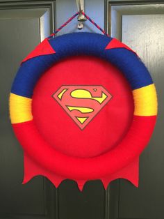 a red and blue wreath with a superman symbol hanging from it's front door