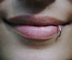 a woman's nose with a ring on the tip of her lip and it is visible