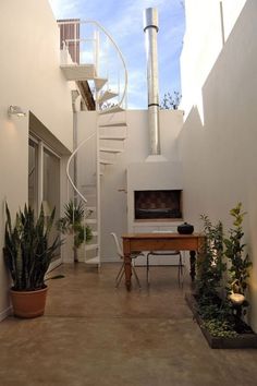 a white staircase leading up to a living room with potted plants on the floor