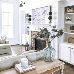 a living room filled with furniture and a fire place in front of a white fireplace