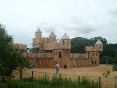 a large wooden castle like structure in the middle of a park