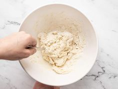 a person mixing food in a white bowl