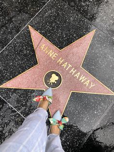 someone's feet are standing on the hollywood walk of fame star in front of them