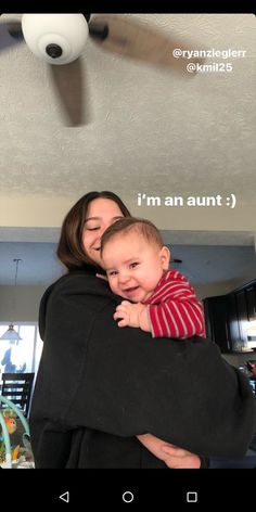 a woman holding a baby in her arms with the caption i'm an adult