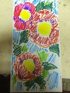 an art project with colored crayons on paper and flowers in the middle,