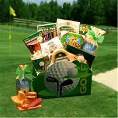 a golf gift box filled with assorted items on the green grass in front of a hole