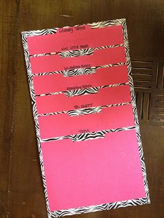 a pink and zebra print binder sitting on top of a wooden table