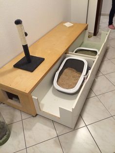 a cat litter box under a wooden table