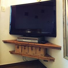 a flat screen tv sitting on top of a wooden shelf