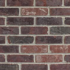 an old brick wall with red and brown bricks