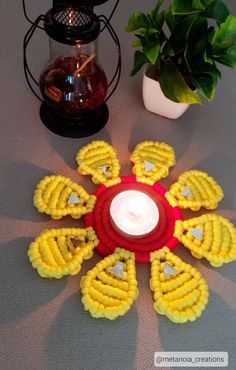 a candle is sitting on a table next to some flowers and a potted plant