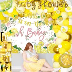 a baby shower is on the wall with lemons and oranges around it,