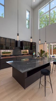 a large kitchen with black cabinets and counter tops