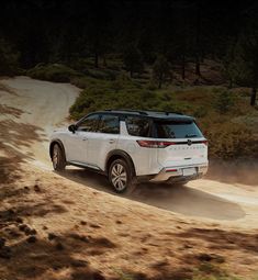 a white suv driving down a dirt road