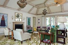 a living room filled with furniture and a fire place under a chandelier in front of a fireplace