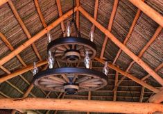 a ceiling made out of wood and bamboo with chandeliers hanging from the rafters