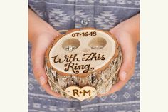 a person holding a wooden ring holder with two rings in it's center and the words, i will this ring?