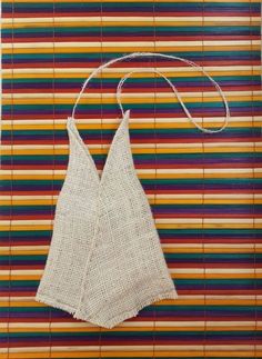 a piece of cloth hanging from a string on top of a wall with multicolored stripes