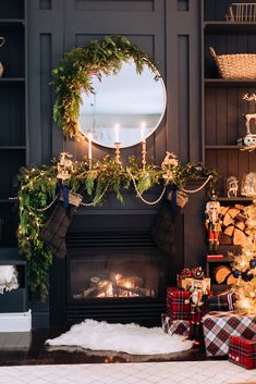 a living room decorated for christmas with presents and stockings on the fireplace mantels