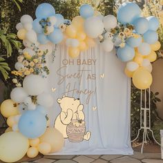 a winnie the pooh themed baby shower is set up with balloons and streamers