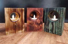 three wooden candle holders with candles in them