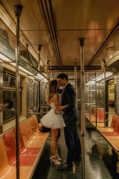 a man and woman are kissing on a subway train together, dressed in tutu skirts