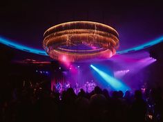 a group of people that are standing in front of a stage with lights on it