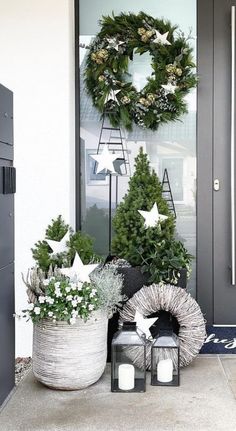 christmas wreaths and potted plants on the front porch