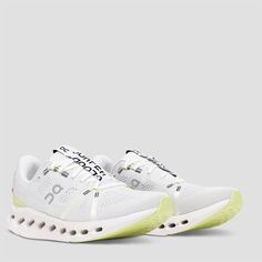 a pair of white sneakers with neon green accents on the soles and upper part of the shoe