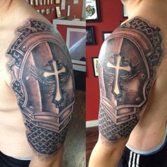 a man with a cross and shield tattoo on his arm