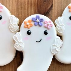 three decorated cookies sitting on top of a wooden table