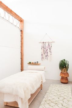 a white bed sitting next to a plant in a bedroom