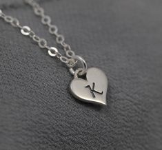 "Sweet and lovely, a dainty Sterling Silver heart is engraved with the initial of your choice. This charming necklace makes a thoughtful gift, to wear close to her heart. Featuring: ♥ a smooth, Sterling Silver heart measuring 12 x 8mm (approximately just under 1/2\" by just over 1/4\") ♥ hung on sparkling Sterling Silver chain in your choice of lengths ♥ packaged in a box with floral band, ready for gift giving ♥ add additional charms from my shop to customize further" Silver Heart Pendant Initial Necklace For Gift, Silver Heart Pendant Initial Necklace As A Gift, Heart Shaped Initial Necklace For Gift, Heart Pendant Necklace With Initials For Gift, Heart Pendant Necklace With Initials As Gift, Personalized Silver Heart Necklace As Gift For Her, Personalized Heart Necklace As Gift For Her, Dainty Heart Pendant Initial Necklace As Gift, Dainty Engraved Open Heart Charm Necklace